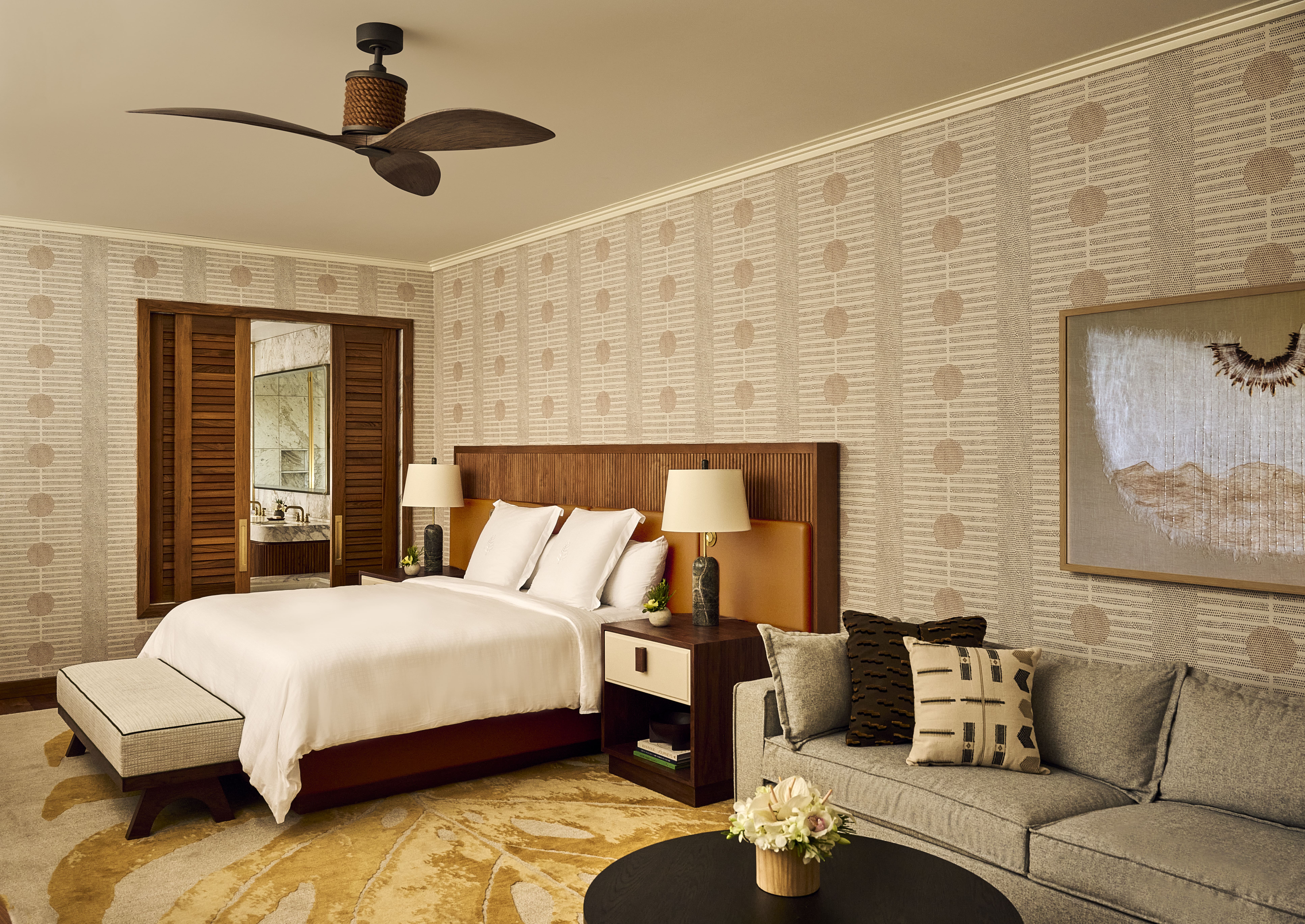 A bedroom at the luxury Four Seasons Maui suite feautring original textile artwork.
